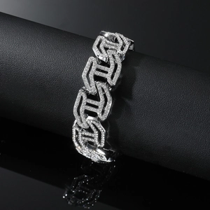 Close-up of silver Cuban link bracelet with full diamond inlay on black stand