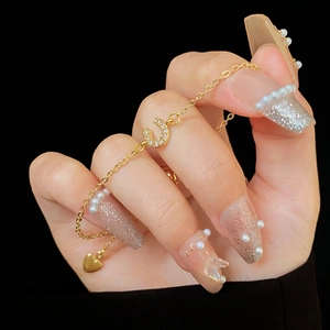 Détail macro du pendentif en U doré serti de zircons sur un bracelet coulissant chic