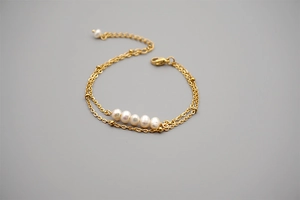 Detail view of double-layer gold titanium steel bracelet with five freshwater pearls