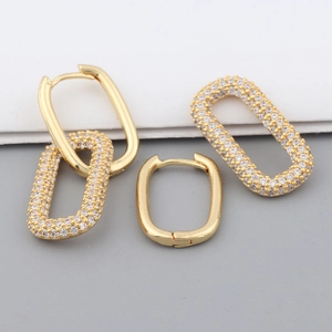 Detail of gold oval hoop earrings with detachable sparkling zircon pendant charms