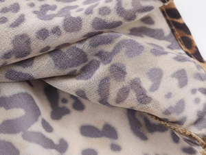 Dettaglio macro della trama leopardata e delle cuciture fini sul vestito
