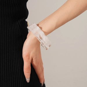 Detail of wide open cuff bracelet featuring white translucent marble pattern on wrist