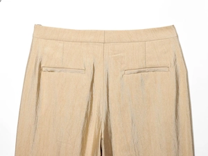 Detail van een champagnekleurige broek met hoge taille, de achterkant en de zakken