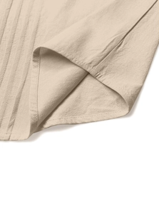 Macro shot of apricot linen shirt showing side seam details and vertical pleated texture