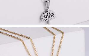 Détail du pendentif arbre de vie en argent et or sur une chaîne fine en acier
