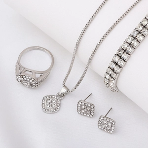Macro view of silver geometric rhinestone jewelry set including ring and necklace