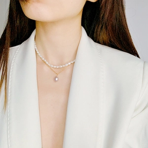 Gros plan du collier double rang en perles d'eau douce avec pendentif baroque