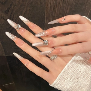 Long almond press-on nails with nude pink cat-eye gradient and sparkling rhinestones