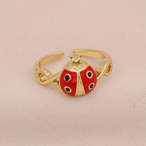 Macro shot of a red and black ladybug open ring with a gold-tone metallic band