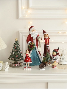 Miniature resin Christmas figurine set displayed on fireplace mantel with warm lights