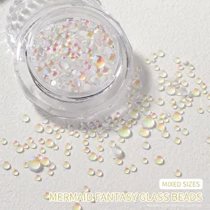 Close-up of mixed size aurora mermaid glass beads for nail art in a clear round container