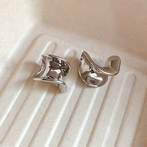 Detailed view of silver liquid metal C-shaped stud earrings with irregular twisted surface