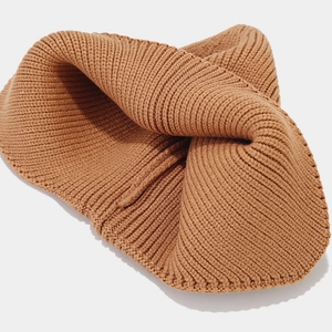 Close-up of caramel winter knit beanie showing thick ribbed texture and warm fabric