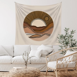 Detail of bohemian tapestry featuring abstract sun and mountain shapes on white wall