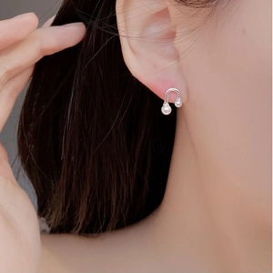 Detailed view of U-shaped 925 silver pearl earring on ear showcasing minimalist design