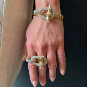 Detail of luxury gold-plated link ring and bracelet set with pave zircon stones on hand