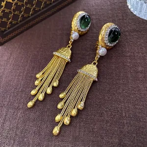 Boucles d'oreilles vintage avec émeraude ovale, glands dorés et perles sur lin brun