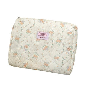 Quilted floral cotton makeup bag with orange and blue flower patterns and metal zipper