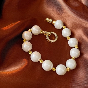 Close-up of elegant pearl bracelet with gold spacers and shimmering zircon pave buckle
