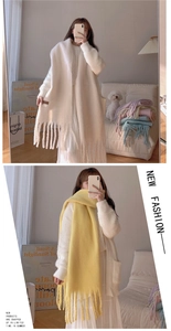 Detail of soft macaron colored tassel scarf in cream and yellow on a female model