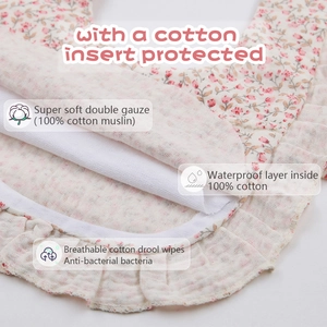 Detail of pink floral cotton bib showing breathable double gauze and waterproof layer