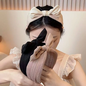 Detail of wide bow headband with knitted herringbone texture in beige and black