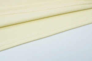 Detailed macro view showing professional white double-line overlock stitching on beige fabric