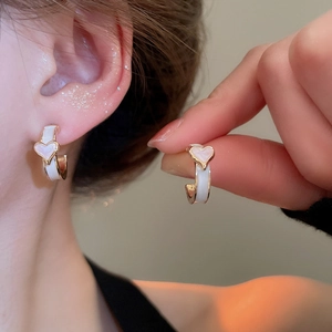 Vue détaillée des boucles d'oreilles fleur émaillée rose, cœur et perle portée