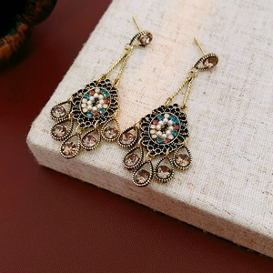 Macro detail of vintage floral tassel earrings with zircon diamonds and small beads