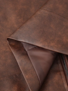 Gros plan sur la texture vintage d'une veste en simili cuir marron avec doublure et zip métal