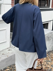 Back view of a casual navy blue long-sleeved jacket worn by a model in autumn scenery