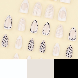 Almond-shaped press-on nails featuring cow print, silver swirls, and white french tips