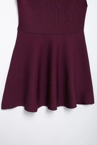 Detailed macro view of dark purple knitted fabric texture and elegant A-line pleated hem