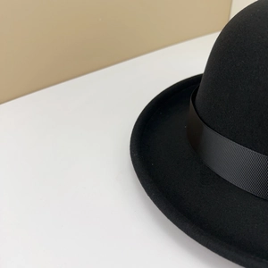 Close-up of black wool felt fedora hat featuring a wide matching grosgrain ribbon band