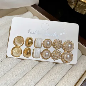 Set of 12 vintage pearl and geometric gold stud earrings in a luxury jewelry box