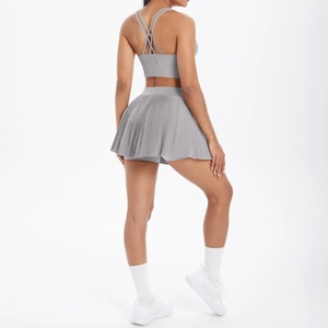 Vue arrière d'un ensemble de sport gris avec soutien-gorge croisé et jupe plissée