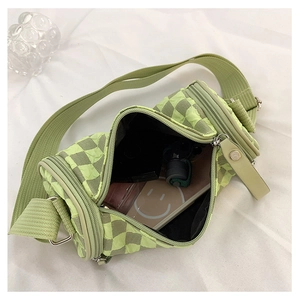 Detail view of green checkerboard barrel bag interior showing phone and essentials