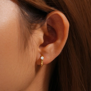 Close-up of gold plated 925 sterling silver hoop earring with 4-claw set cubic zirconia
