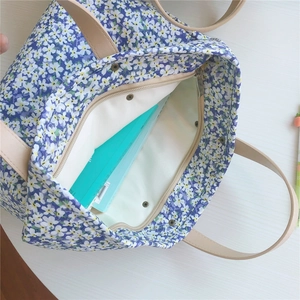 Close-up of small floral tote bag with zipper closure and spacious interior compartment