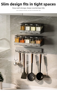 Detail of kitchen wall-mounted storage rack with spice jars and hooks on marble wall