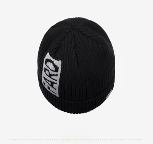 Detailed top view of a black rib-knit winter beanie featuring gray jacquard letters