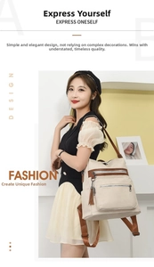 Detail of off-white faux leather backpack with multiple zipper pockets and tassel charm
