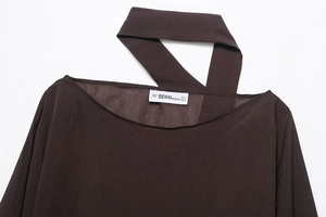 Detail of the crew neck collar and metal rivet texture on this brown fashion poncho top