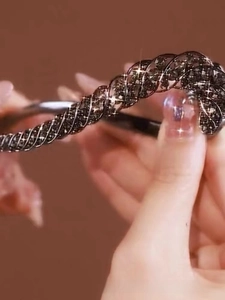 Close-up of flexible twisted hair clip with shimmering black rhinestones and spiral detail