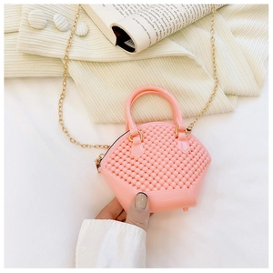 Detail of pink mini jelly shell bag with bubble texture and gold chain strap in hand