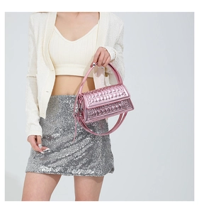Detailed macro view of pink metallic crossbody bag with textured geometric quilting
