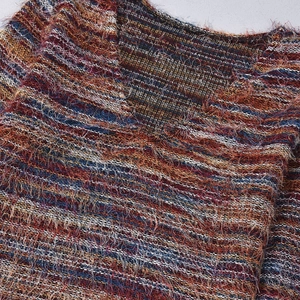 Detail of colorful striped knit top with textured fringe and V-neckline finish