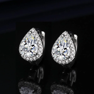 Macro shot of silver teardrop earrings with pear-cut cubic zirconia in a halo setting