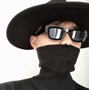 Close-up of retro square black sunglasses with wide-brim hat and knit sweater