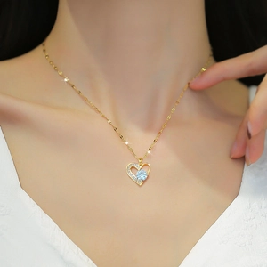 Close-up of gold-plated heart pendant with sparkling crystals on a model's neck